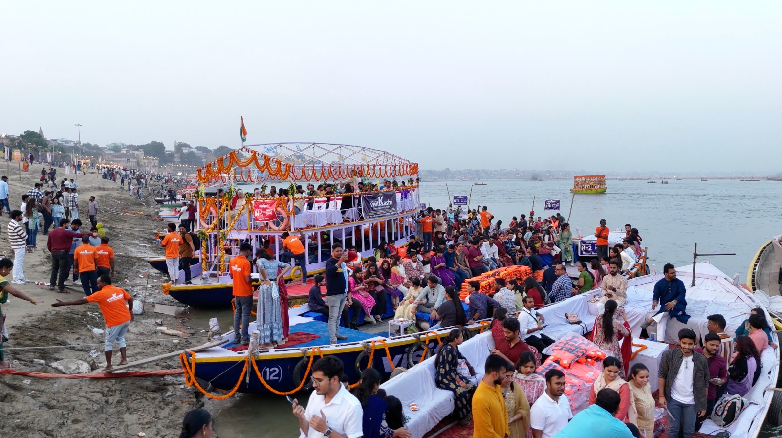 Guests gathering to board decorated boats in Varanasi